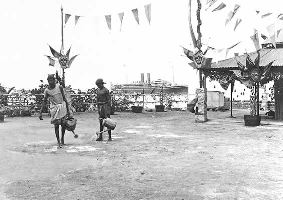 The Maloja (in the background) docks in Aden. The bunting is up to welcome King George and Queen Mary within the week.